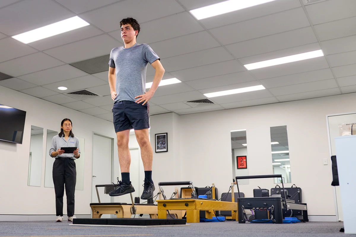 Runner mid-jump in a VALD jump testing (ForceDecks) at Performance Podiatry & Physiotherapy in Brisbane's West End.